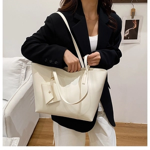 Fashionable cream tote bag with matching pouch worn by model for daily commute style