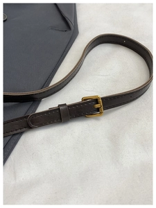 Detailed macro view of dark brown leather strap with vintage gold buckle and neat stitching