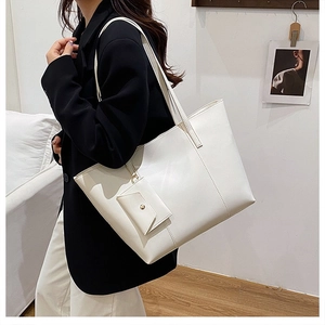 White large capacity tote bag with matching pouch shown on a model for scale and style