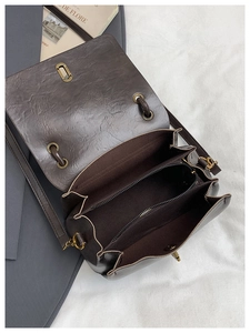 Detail of vintage brown crossbody bag showing three inner compartments and bronze hardware