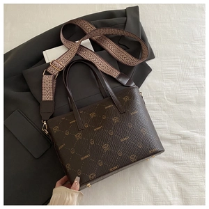 Détail du sac seau marron foncé avec motif animalier et bandoulière tissée