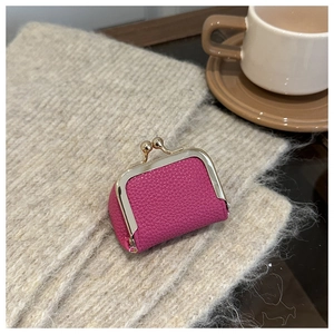 Mini rose pink litchi leather jewelry pouch with gold metal clasp on cozy knit blanket