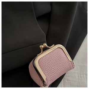 Close-up of pink litchi grain leather pouch with vintage gold metal frame closure