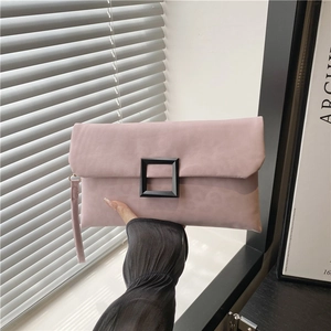 Pink minimalist envelope clutch bag featuring a large black buckle and wrist strap