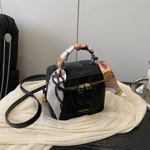 Detail of black crocodile texture bag with colorful silk scarf handle and gold fashion logo