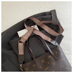 Détail du sac seau marron foncé avec motifs de dessins animés et bandoulière tissée