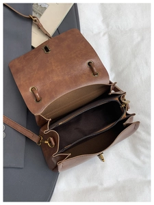 Detail view of the brown vintage crossbody bag with three internal compartments and hardware