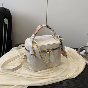 Detail of white marble textured PU leather bag with silk scarf handle and gold hardware