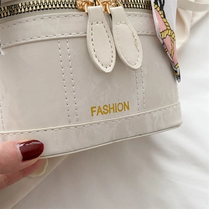 Detail of off-white leather handbag with double zipper and fashion gold lettering