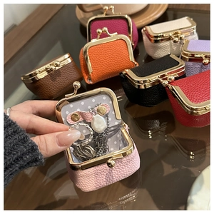 Mini lychee leather jewelry pouches with metal clasps showing rings and necklaces inside