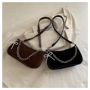 Détail de sacs bandoulière mats avec chaîne argentée et pendentif nœud en perles