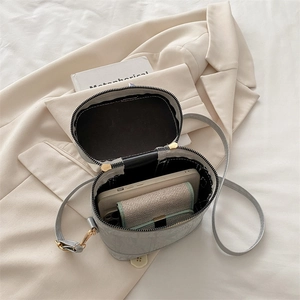 Detailed interior of the grey faux leather crossbody bag showing phone and wallet storage