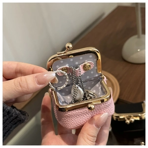 Pink pebbled leather jewelry pouch with metal clasp and polka dot lining interior detail