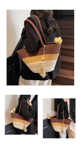 Detailed view of woven straw tote bag with gradient stripes and tassel bead charm