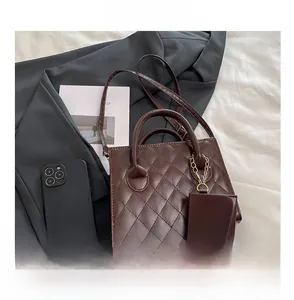Détail du sac matelassé marron foncé avec mini pochette assortie et chaîne dorée