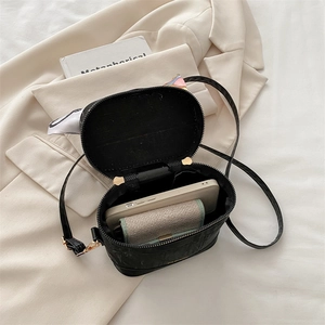 Top view of black matte leather crossbody bag showing spacious interior with fashion logo