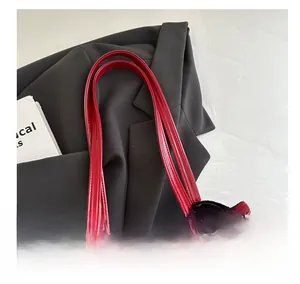Detailaufnahme der tiefroten Lackleder-Tote-Bag mit glänzender Oberfläche und Griffen