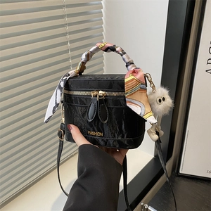 Detail of black wrinkled leather bag with fashion plaque and silk scarf handle