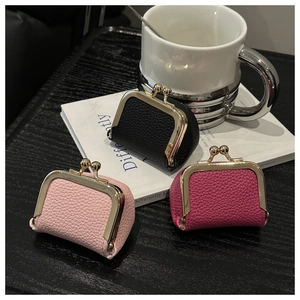 Detailed close-up of mini kiss-lock leather coin purses with textured lychee grain finish