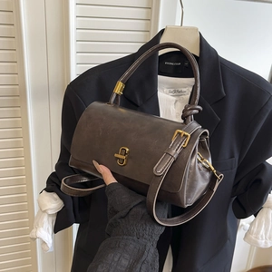 Brown vintage square handbag with knot handle and gold buckle on a blazer background