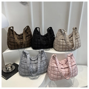 Dettaglio di borse tote trapuntate in cinque colori su supporti in stile minimalista