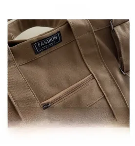 Close-up of brown canvas tote bag with metal zipper pocket and fashion instinct woven label