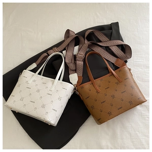 Detail of patterned tote bag with wide jacquard shoulder strap and gold hardware