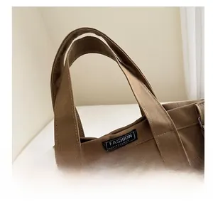 Detail of sturdy brown canvas handle and fashion instinct tag on a casual bucket bag