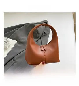 Close-up of brown crescent hobo bag featuring smooth leather texture and metal zipper