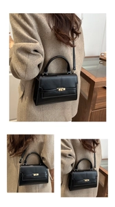 Close-up of minimalist black leather crossbody bag with elegant gold metal buckle detail