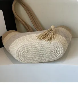 Detail view of multicolored woven straw bag featuring striped pattern and boho tassels