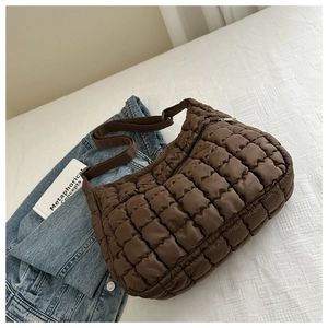 Close-up of brown quilted puff shoulder bag with square padding texture and zipper