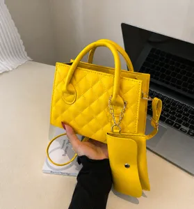 Close-up of quilted yellow leather handbag with matching round coin purse and dual handles