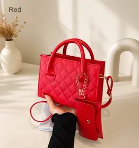 Detail of red quilted handbag with matching coin purse and golden metal chain strap