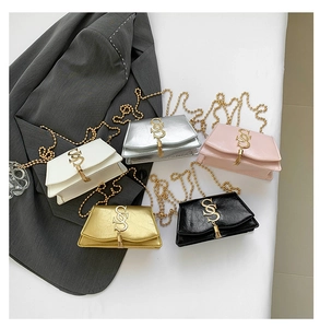 Detailed macro of assorted colorful mini chain bags with gold logo and tassel hardware