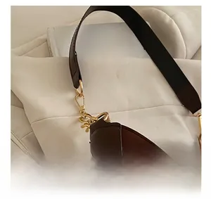 Dettaglio degli accessori in metallo dorato e cuciture in pelle scamosciata marrone borsa