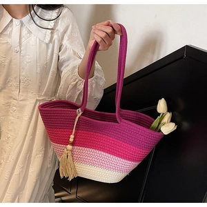 Close-up of woven tote bag with purple gradient stripes and wooden bead tassel detail