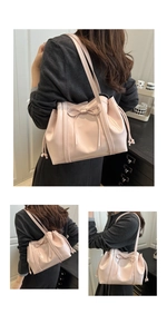 Detail of pink bow tote bag with drawstring side and glossy faux leather finish