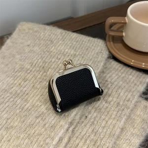 Mini black pebbled leather coin purse with vintage gold clasp on cozy knit background