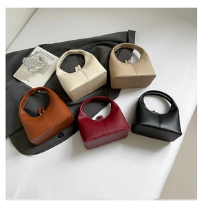 Minimalist faux leather handbags in five colors with a curved handle and zipper closure