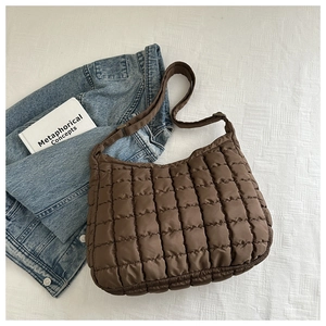 Close-up of deep brown quilted puffer hobo bag with a soft texture and adjustable strap