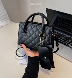 Detailed view of a black quilted handbag set with a small matching pouch and gold chain