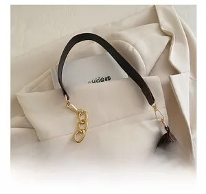 Dettaglio della borsa hobo in pelle scamosciata marrone scuro con catena dorata e tracolla
