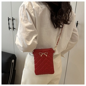 Sac bandoulière rouge matelassé avec nœud doré et bandoulière en chaîne élégante