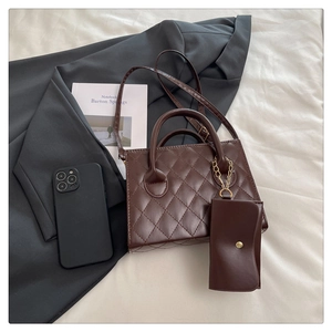Brown quilted crossbody bag set with golden chain detail on minimalist office scene