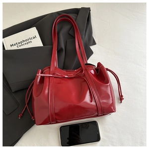 Macro detail of glossy red tote bag with drawstring bow and polished mirror finish