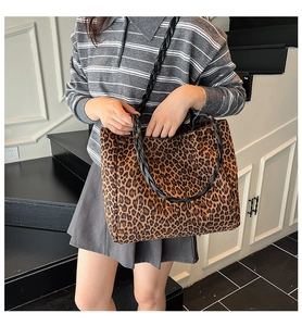 Detail of leopard print tote bag featuring black woven handles and large capacity design