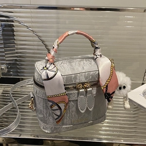 Gray pleated leather handbag with silk scarf, plush pendant and fashion logo on mirror shelf