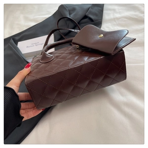 Detail of dark brown quilted leather handbag and matching small flap pouch set