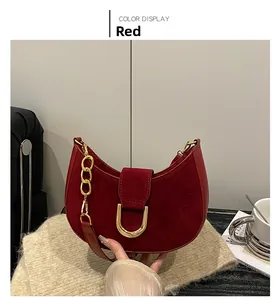 Dettaglio borsa hobo in pelle scamosciata rossa con fibbia a ferro di cavallo dorata